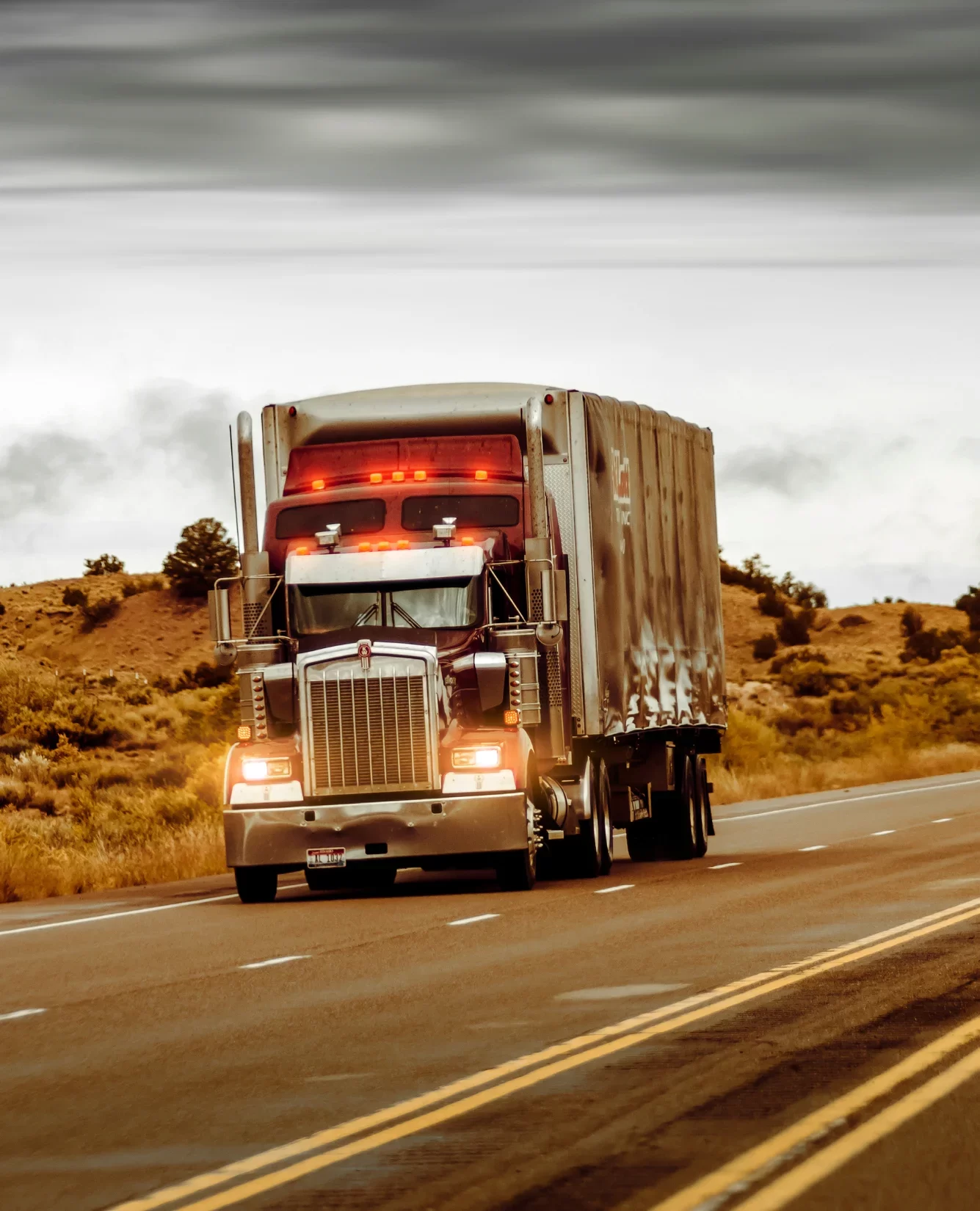 A semi truck driving down a road.